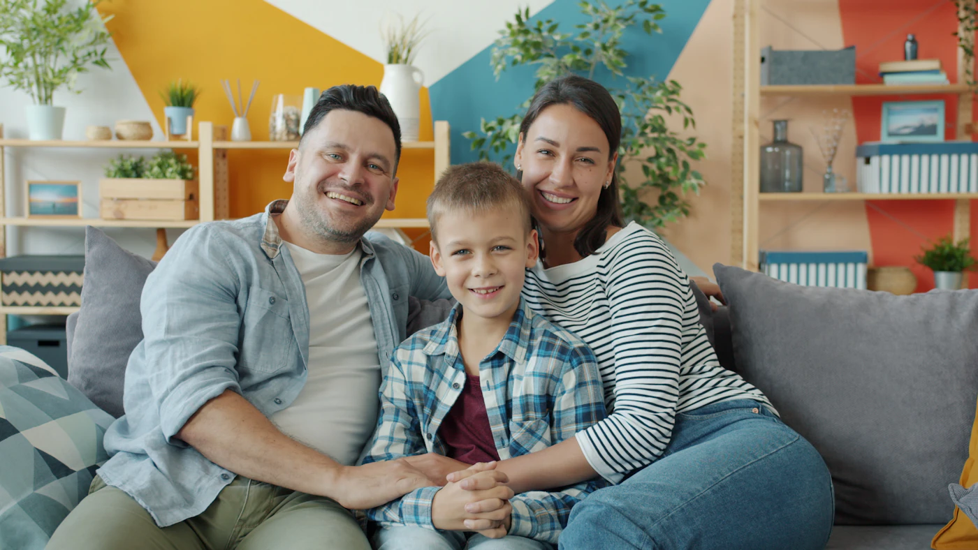 A happy family of three on a sofa