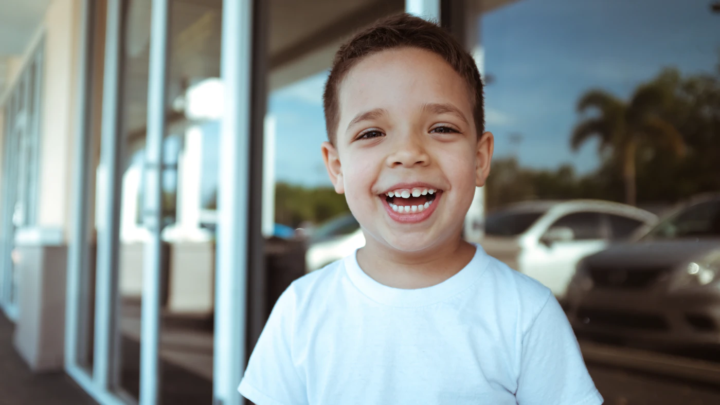 A young boy smiling brightly